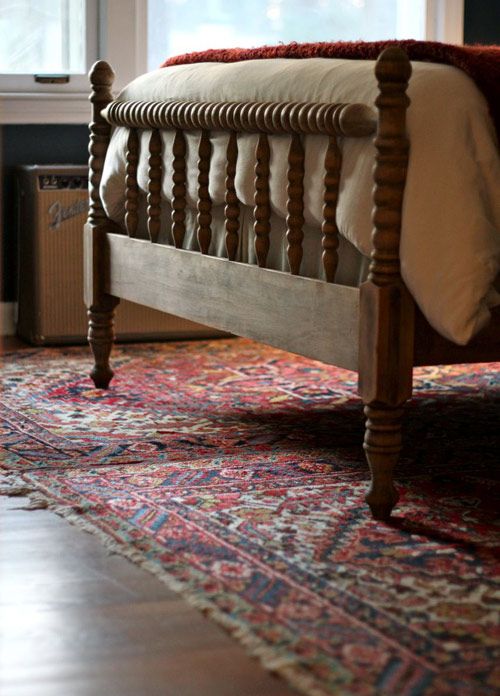 a bed sitting on top of a rug in a bedroom next to a fire place