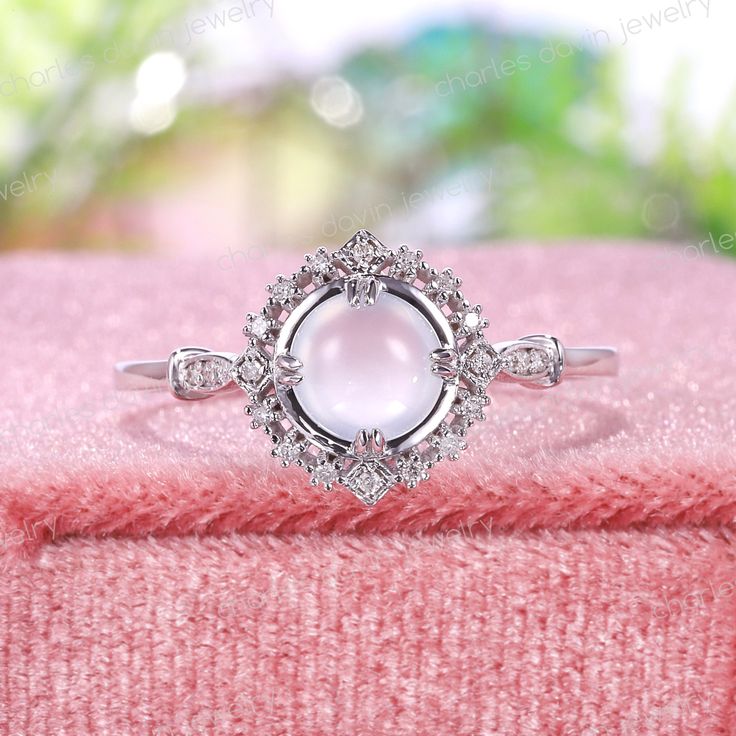 a close up view of a ring on a pink blanket