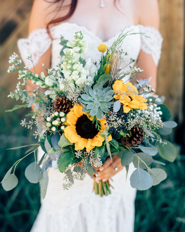 a bride holding a bouquet of flowers and greenery