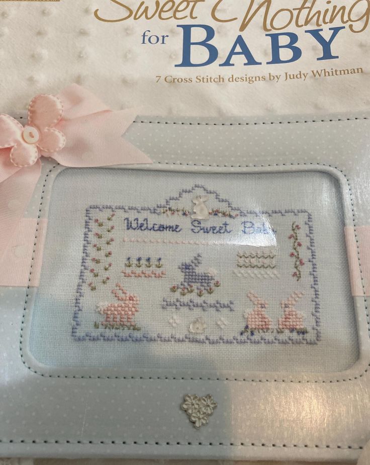 a cross stitch book with a pink bow on it's cover and the title sweet nothing for baby