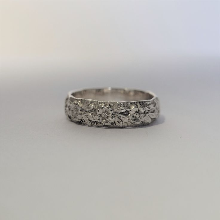 an antique wedding band with flowers and leaves in white gold or palladine silver