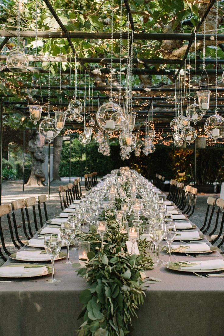 a long table with chairs and chandeliers hanging from it's ceiling is shown