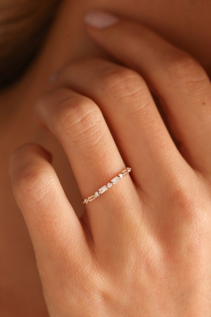 a woman's hand with a diamond ring on it