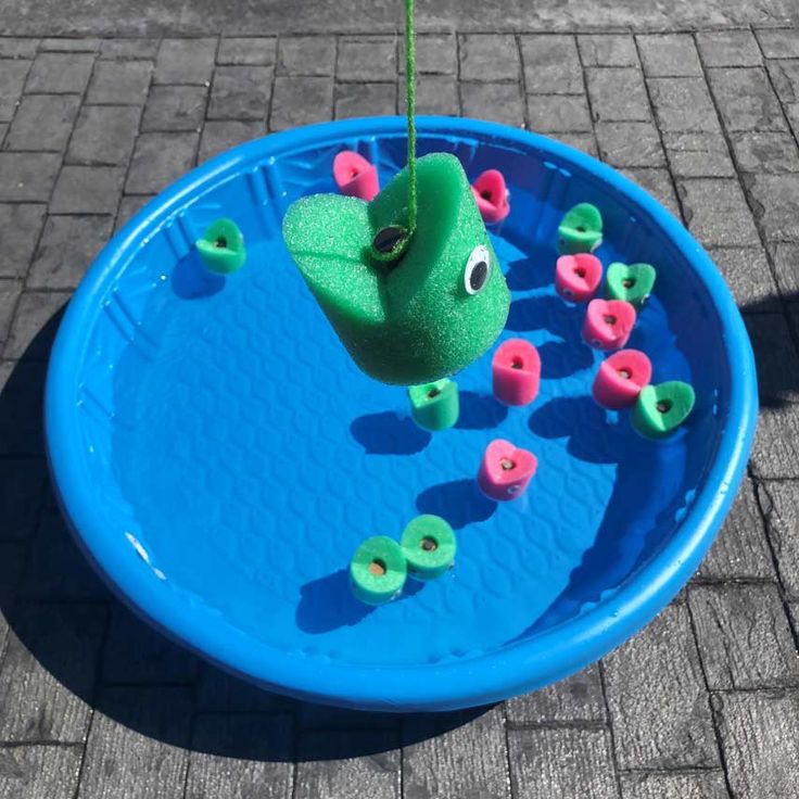 a toy fish in a blue bowl with pink and green sprinkles on it