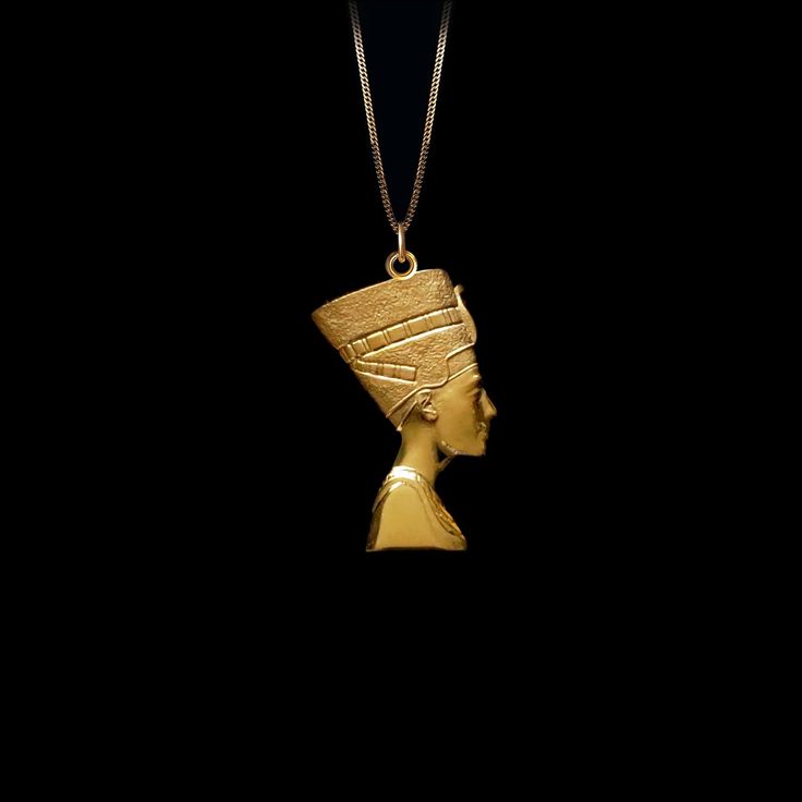 a gold necklace with an egyptian head in the shape of a woman's head