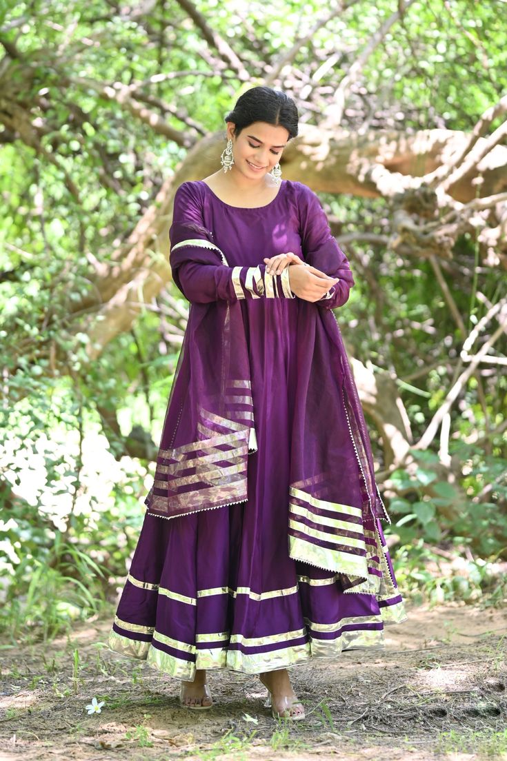 PRODUCT DESCRIPATION This festive season , be ready to impress! Shop it now and make Diwali memorable!Anarkali :- Upada silkPant :- CottonDupatta :- Organza silkClosure Used:- Side zipColor:- Deep purpleCare Instructions :- Dry clean onlyModel Size :- Model is wearing XS sizeModel Height :- 5.5'DISCLAIMER :- Slight color variations may occur due to different screen resolution. Anarkali Art Silk Salwar Kameez With Dabka, Navratri Silk Anarkali Set With Dabka Details, Silk Anarkali Set With Dabka For Navratri, Anarkali Art Silk Sharara With Dupatta, Dabka Silk Anarkali Set For Navratri, Festival Slub Silk Anarkali Set With Dabka, Purple Silk Kurta With Gota Work, Semi-stitched Raw Silk Anarkali Set For Diwali, Festive Silk Anarkali Set With Gota Work