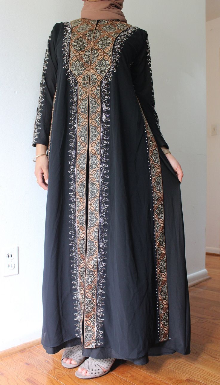 Black Muslim Abaya long sleeve, long dress with brown details on the chest, sleeve and down the entirety of the dress.  Dress it up for a special day such as Eid, Nikkah or Walima; or simply dress it down for the mosque, party or gathering.  Please feel free to check out the rest of our store for more dresses and reach out to us for any questions! Black Long Sleeve Abaya For Fall, Modest Black Abaya With Long Sleeves, Elegant Long Sleeve Thobe With Dabka Embroidery, Elegant Long Sleeve Thobe With Dabka, Modest Long Sleeve Thobe For Eid, Modest Black Long Sleeve Abaya, Modest Long Sleeve Black Abaya, Long Sleeve Thobe For Eid, Formal Embroidered Long Sleeve Thobe