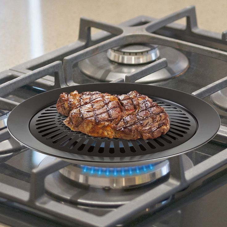 a steak is being cooked on the gas stove