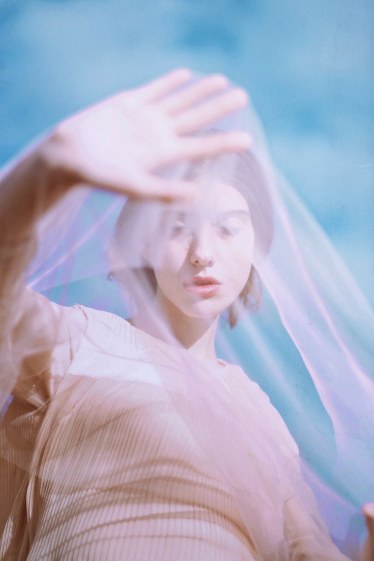 a woman is holding her hands up in the air while wearing a veil over her head