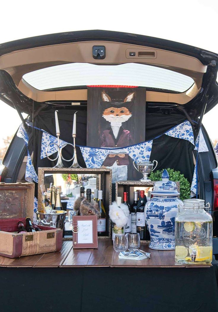 the back of a car with an open trunk filled with bottles and other items on it