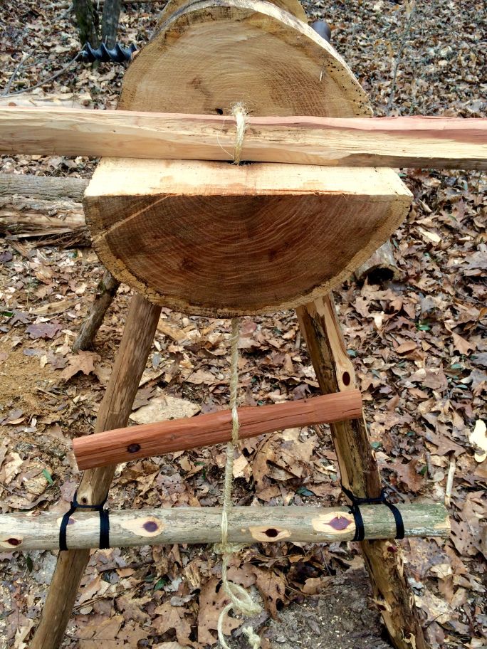 a wooden bench made out of logs and rope