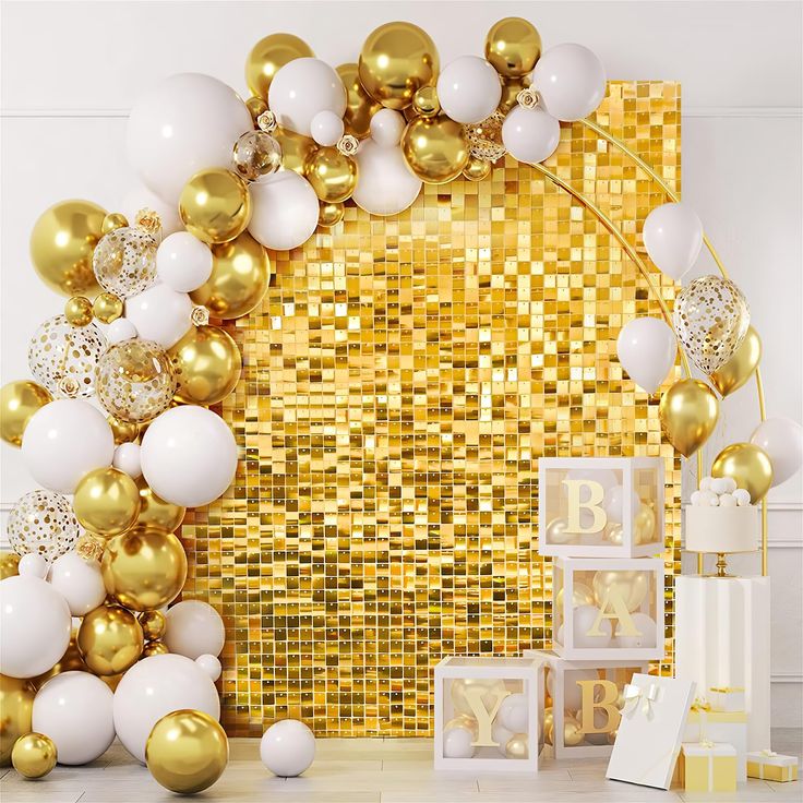 gold and white balloons are on display in front of a golden mosaic wall with the letter b