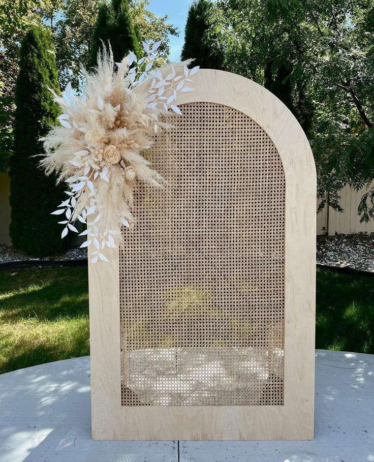 a wooden frame with some flowers on the front and back side, sitting on top of a cement slab