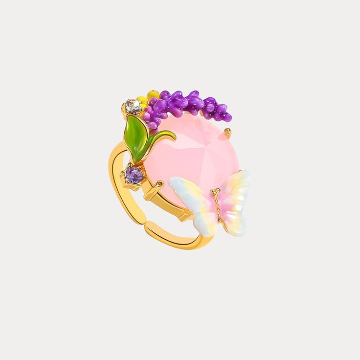 a pink ring with purple flowers and butterflies on it's side, sitting against a white background