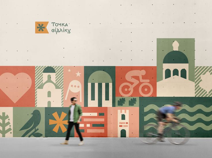 two people riding bikes in front of a mural