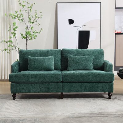 a living room with a green couch and white rug