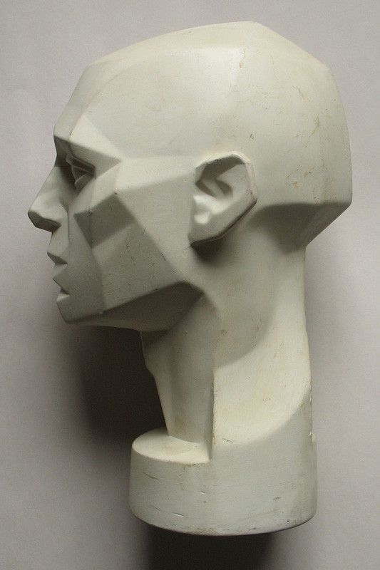 a white sculpture of a man's head with his eyes closed on a gray background