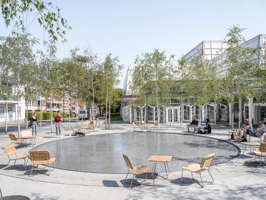 people are sitting around in the middle of a circular area with chairs and tables on it