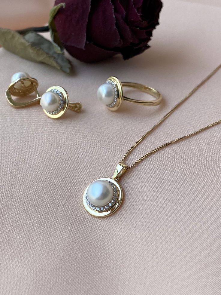 "14K 18K Gold Freshwater Halo Pearl Set-Chunky Pearl Earrings Pearl Zircon Halo Ring and Necklace Set- Bridal and Jewelry- Memorial Day Gift MATERIAL SPECIFICATIONS Stock Code: Z098448-49-50 Metal : 14K 18K Solid Gold Color: Yellow gold, Rose gold, White gold. Pearl Color : White Personalization in Ring Size is possible. THE WEIGHT OF OUR PRODUCTS MAY VARY + - 10% GR WHY OUR PEARL JEWELRY? The elegant and timeless pearl jewelry by BirinciJewelry is a musthave in every person's wardrobe. Natural Elegant Gold Round Bridal Sets, White Gold Plated Jewelry For Wedding, Gold Plated Round Jewelry For Wedding, Yellow Gold Wedding Jewelry With Elegant Design, Elegant Yellow Gold Jewelry For Wedding, Gold Plated Round Bridal Sets As Gift, Fine Jewelry Set With Pendant And Matching Earrings, Fine Jewelry Sets With Matching Earrings And Pendant, Gold Plated Bridal Sets Gift