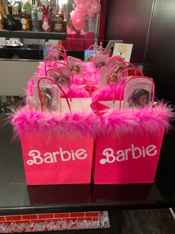 pink bags with barbie dolls in them on display