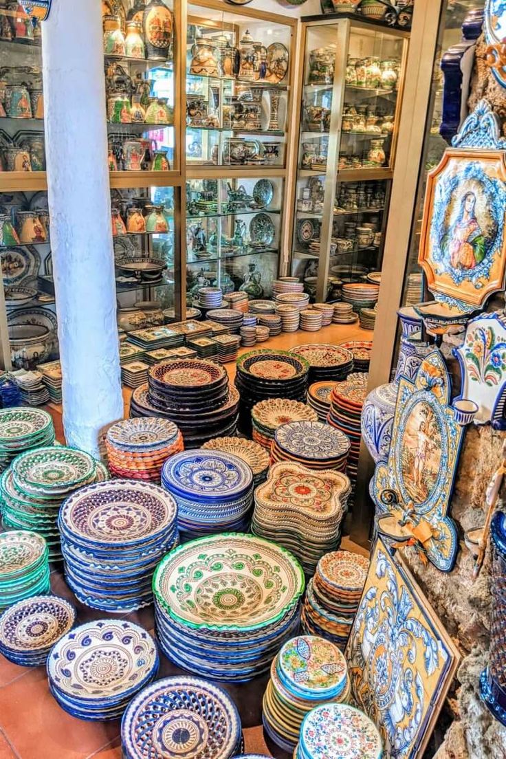 many plates are stacked on top of each other in front of a glass display case