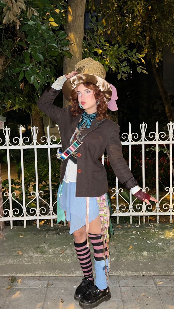 a woman dressed in costume standing next to a white fence