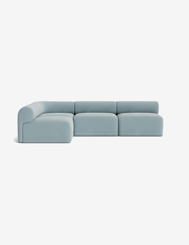 a light blue couch sitting on top of a white floor next to a gray wall