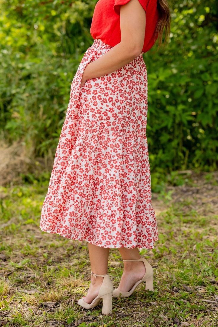 We cannot get over how stylish this skirt is! The beautiful floral print and tiered style fit makes such a cute, elegant look! Wear this skirt to any event and you are sure to receive compliments! We love tucking a blouse into this for a more elevated look or a basic or graphic tee for a casual feel! Self: 100% PolyesterLining: 100% Rayon Hand wash cold. Do not bleach. Lay flat to dry. Low iron if necessary. Red Floral Print Skirt Affordable, Casual Red Floral Print Skirt, Summer Midi-length Rayon Skirt, Red Floral Print Tiered Skirt, Long Floral Print Skirt, Relaxed Fit, Kimono Blouse, Tiered Midi Skirt, Red S, Romper And Jacket