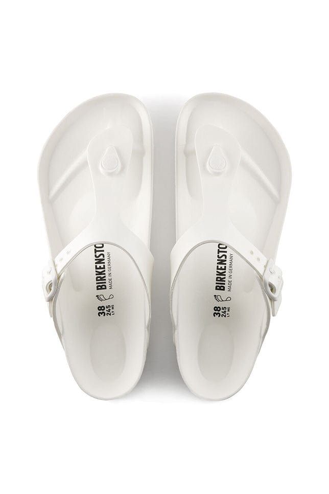 overview photo of the white T style flat rubber sandal White Round Toe T-strap Sandals For Summer, White Casual T-strap Beach Sandals, White Casual T-strap Sandals For Beach, White Toe Post T-strap Sandals For Vacation, White Slip-on Jelly Sandals For Beach, White Synthetic T-strap Sandals For Vacation, Casual T-strap Jelly Sandals For Beach, White Adjustable Jelly Sandals With Round Toe, Casual Beach Jelly T-strap Sandals