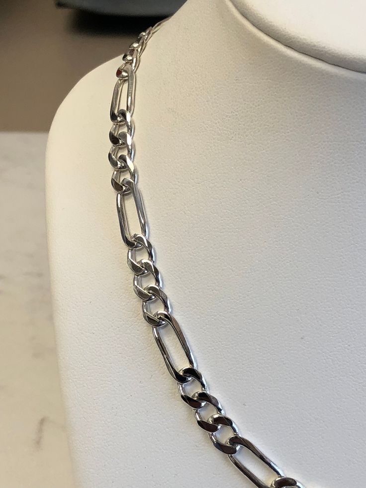 "Sterling Silver Unisex Solid Link Figaro Chain Necklace 18\" in Length. This chain is very flexible and comfortable to wear with its shiny bright plain polished finish. This chain has finished end caps and a lobster claw clasp closure and is 7mm wide and weighs 28.1 grams. This item would Retail for $429.00" Modern Silver Jewelry With Figaro Chain, Silver Figaro Chain Link Necklace, Silver Figaro Link Chain Necklace, Silver Polished Chain Necklace, Classic Silver Figaro Chain Necklace, Silver Figaro Chain Necklace With Oval Links, Sterling Silver Link Necklace With Polished Finish, Sterling Silver Figaro Chain Necklace With Oval Links, Sterling Silver Link Chain Necklace With Polished Finish