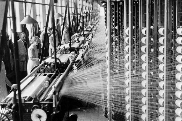 an old black and white photo of people working on machines in a factory with lots of wires