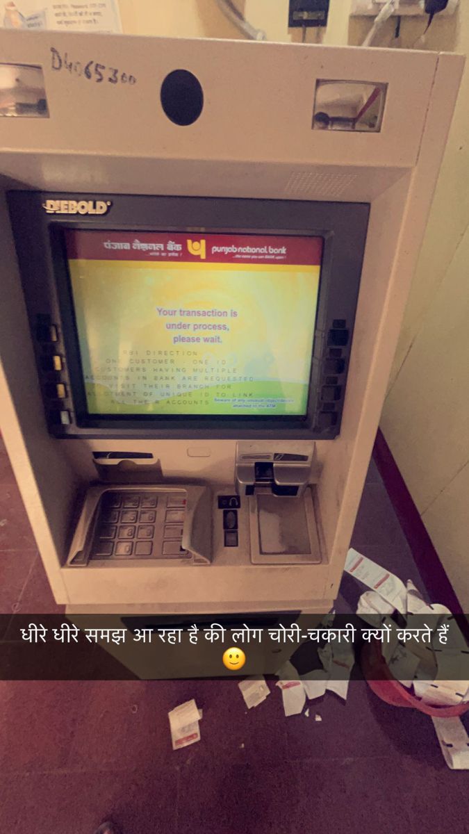 an atm machine sitting on top of a floor next to a pile of papers and other items