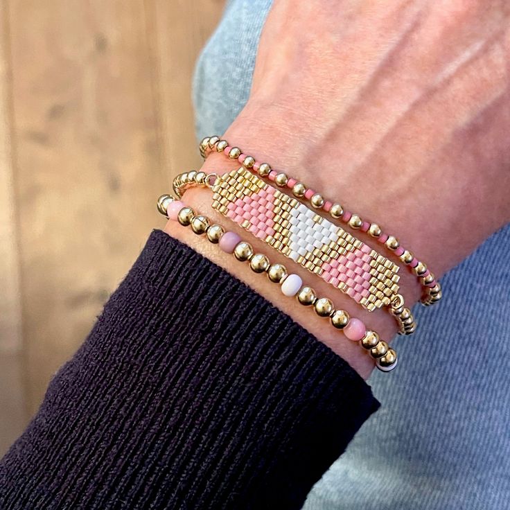 a close up of a person wearing two bracelets on their wrist and one with beads