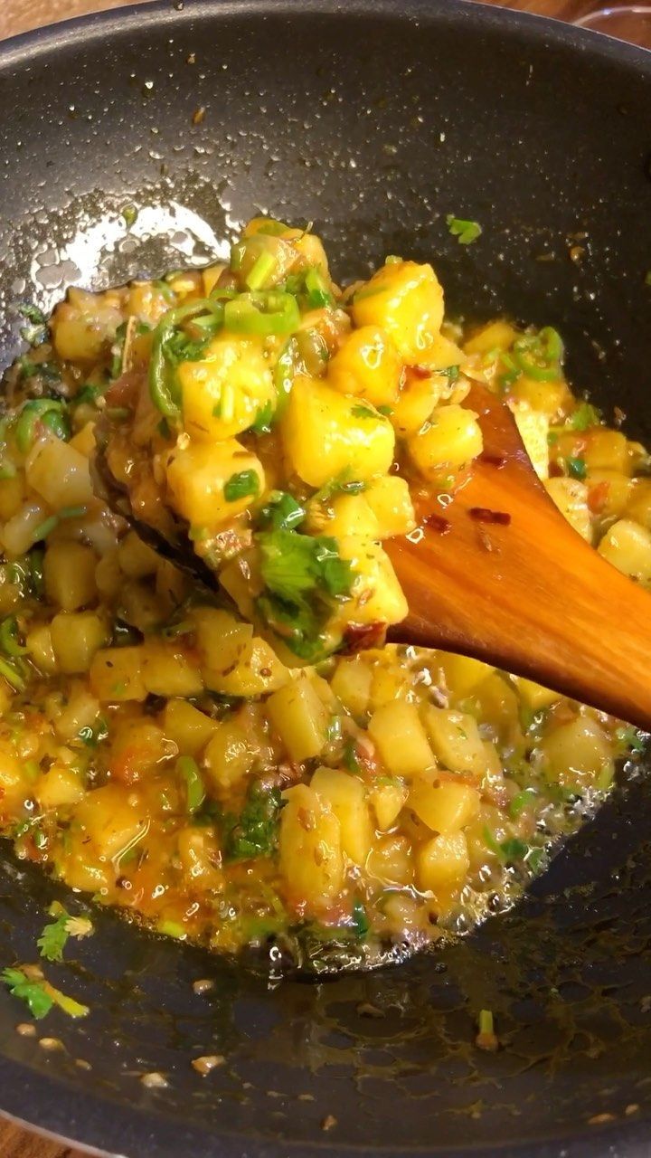 a pan filled with food and a wooden spoon