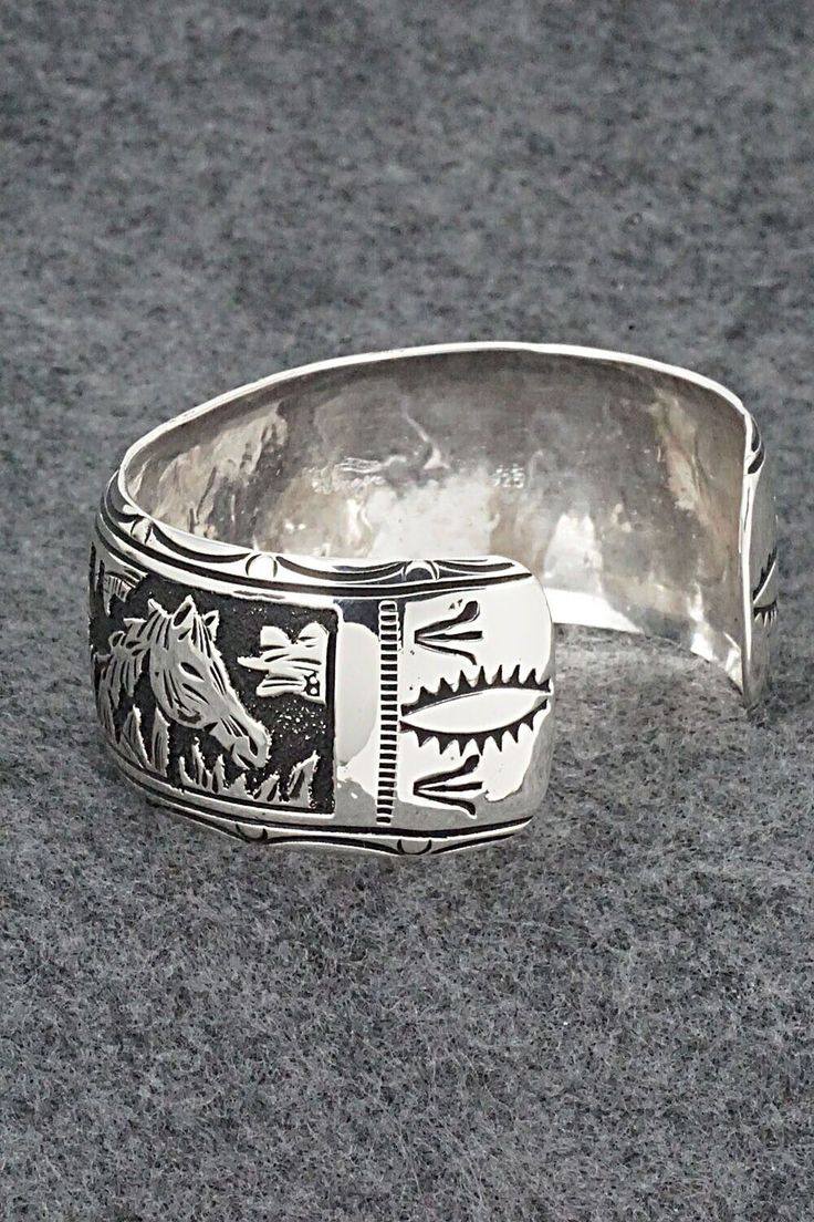 This expertly crafted sterling silver bracelet featuring horses was made by Navajo silversmith Richard Singer. The back is signed R Singer and stamped .925.Size: 5 5/8" (will fit up to a 6 3/4" wrist)Gap: 1 1/8"Width: 1"Free shipping on all orders! We ship with USPS and always include tracking. All orders ship within a day of payment.Returns are accepted up to 30 days after you receive your order. Just send us a message. Our shop offers cash back or store credit. The item must be returned in new Western Sterling Silver Cuff Bracelet Gift, Western Sterling Silver Cuff Bracelet, Western Style Sterling Silver Cuff Bracelet, Western Style Engraved Bracelets For Gifts, Adjustable Western Sterling Silver Bracelet, Sterling Silver Southwestern Bracelet With Polished Finish, Western Style Silver Cuff Bracelet Gift, Western Style Silver Cuff Bracelet As A Gift, Western Style Silver Bracelet For Gift