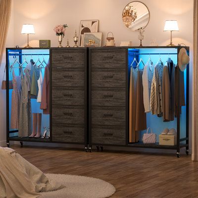 a bedroom with a bed, dresser and clothes on display in the closet next to it