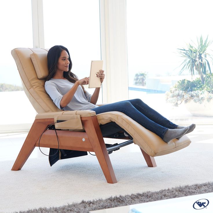 a woman sitting in a recliner holding a book