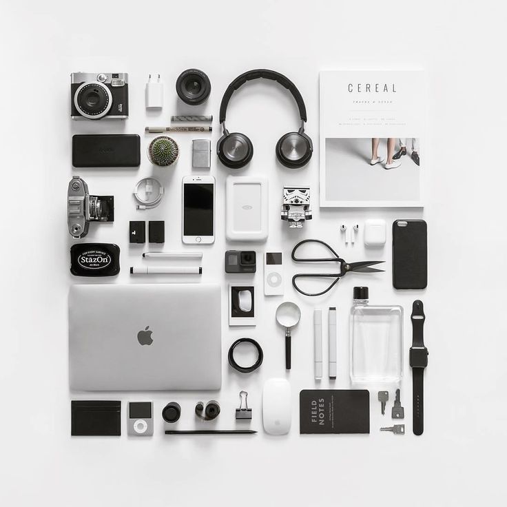 an assortment of electronics and gadgets laid out on a white surface, including a laptop