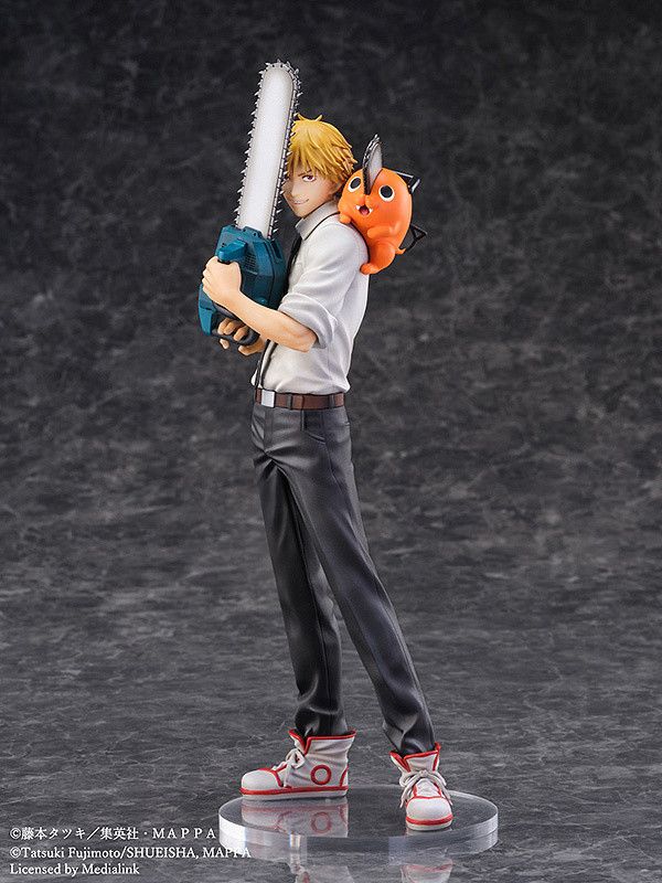 a figurine is holding a chainsaw and an orange object in his hand