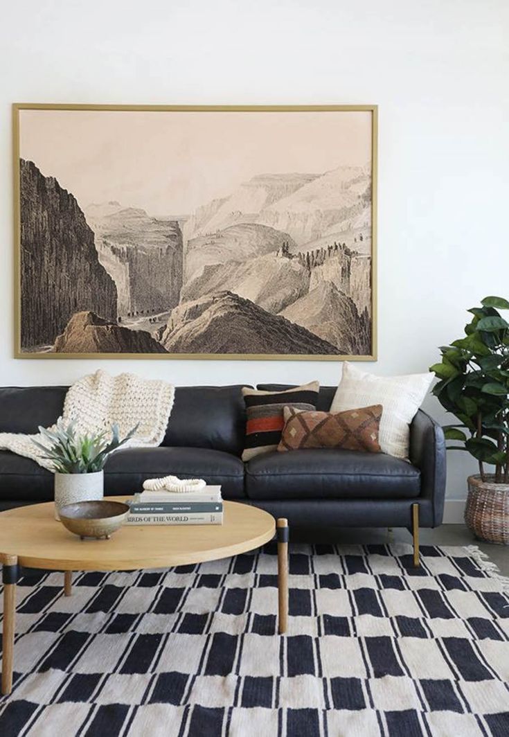 a living room with a couch, coffee table and painting on the wall above it