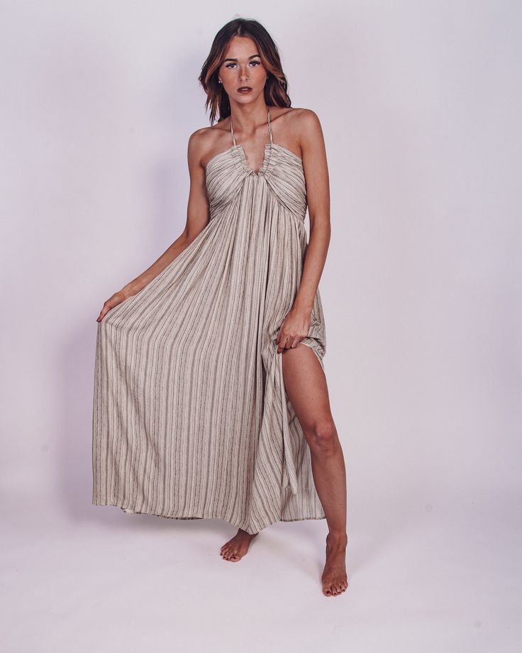 Vacay approved is our From The Source Pocketed Halter Maxi Dress is perfect for any event this season. We love the flowy, lightweight striped fabrication for a classy and flattering fit. Designed with maxi length on a plunging halter neckline, side pockets, partial elastic waistband and an adjustable back tie design. We are swooning over this adorable maxi and you will too! Pair with your favorite heels for a chic look or with sandals to keep it casual! Color: Black/Cream Maxi Length Bump Friend Bohemian Striped V-neck Maxi Dress, Beach Dresses With Vertical Stripes And V-neck, V-neck Dress With Vertical Stripes For Day Out, Chic Maxi Dress With Vertical Stripes, Striped Maxi Dress For The Beach, Striped Maxi Dress With Vertical Stripes For The Beach, Striped V-neck Maxi Dress For Vacation, Chic Maxi Dress With Vertical Stripes For Vacation, Striped Halter Neck Maxi Dress For Beach