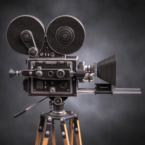 an old fashioned camera sitting on top of a tripod in front of a purple background