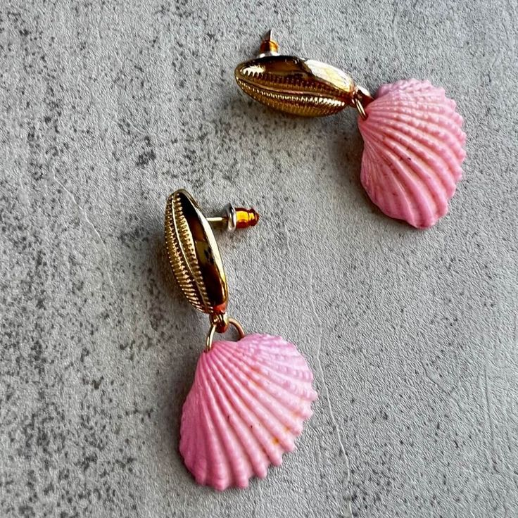 Channel your inner beach babe with Enchanted at Sea Pink Seashell Dangle Coastal Earrings. These playful earrings exude calm and charm, adding a pop of coastal energy to any outfit. Perfect for those who love all things beachy. Pink Jewelry For Beach Party, Pink Jewelry For Beach Party Season, Bohemian Pink Jewelry For Beach Party, Beachy Shell-shaped Earrings For Gift, Pink Beachy Jewelry For Beach Season, Handmade Pink Jewelry For Beach Party, Pink Dangle Earrings For Beach, Beachy Pink Jewelry For Vacation, Pink Dangle Jewelry For Vacation