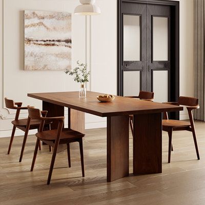 a dining room table with chairs and a vase on it