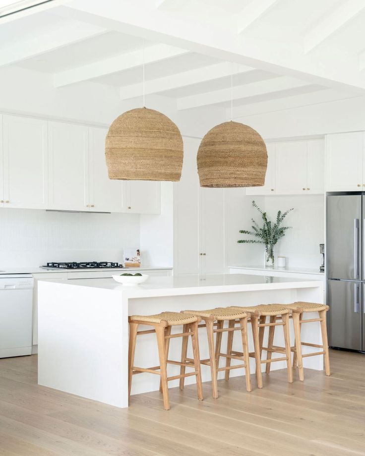 an island with stools in a white kitchen