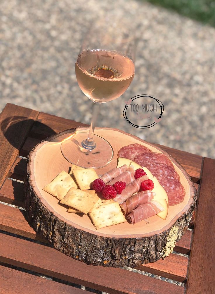 a wine glass and some food on a wooden table