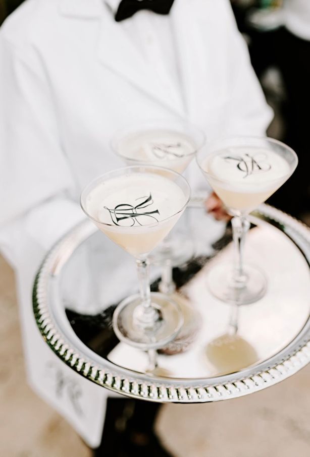 two martini glasses sitting on top of a silver tray