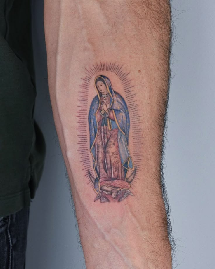 a man's arm with a tattoo of the virgin mary and jesus on it