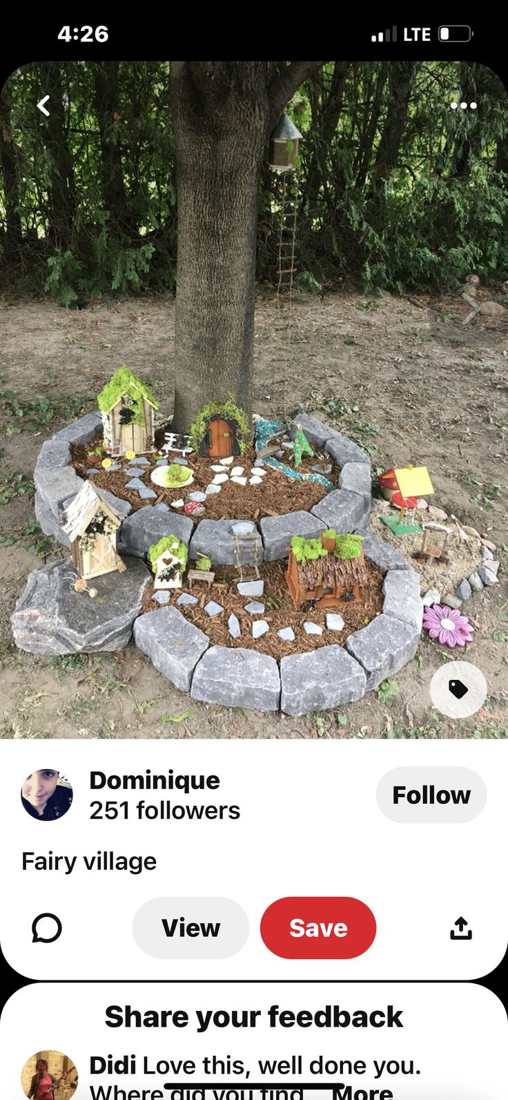 an image of a tree in the middle of a yard with rocks and plants around it