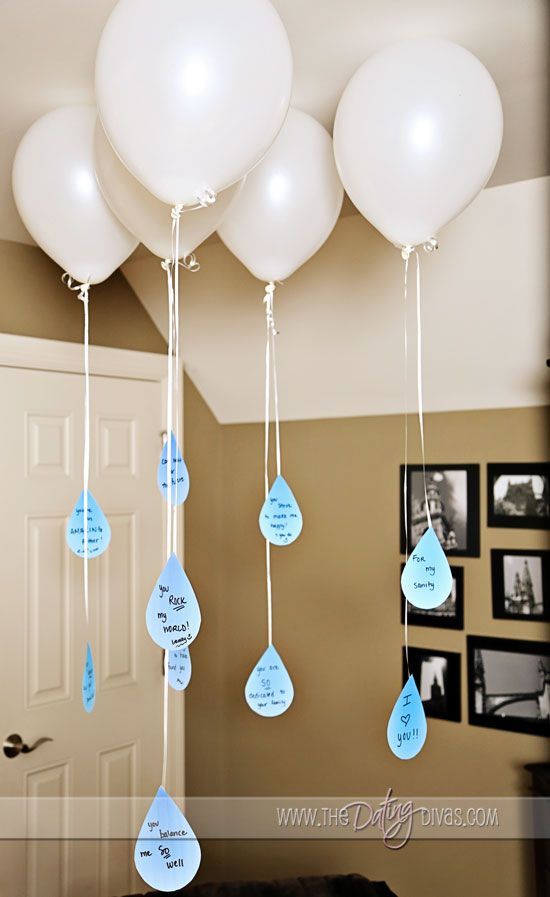 some balloons are hanging from the ceiling with blue and white tags attached to each balloon